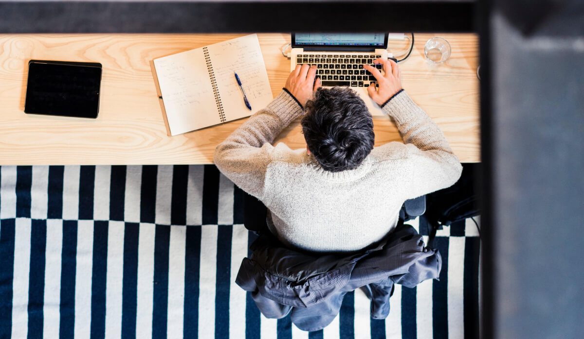 a person sitting at a desk using a laptop ready to rebrand small business