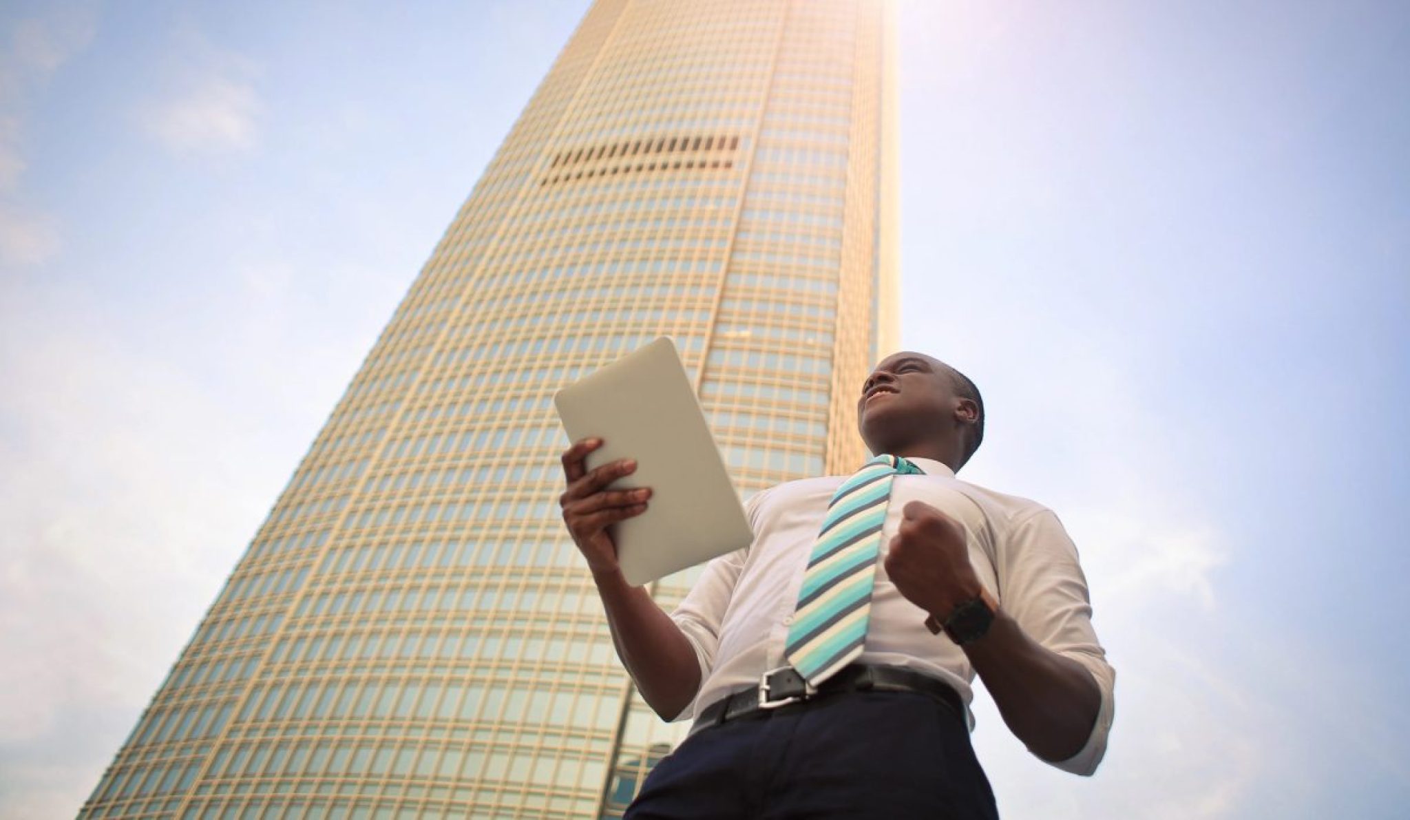a person holding a tablet in front of a tall building