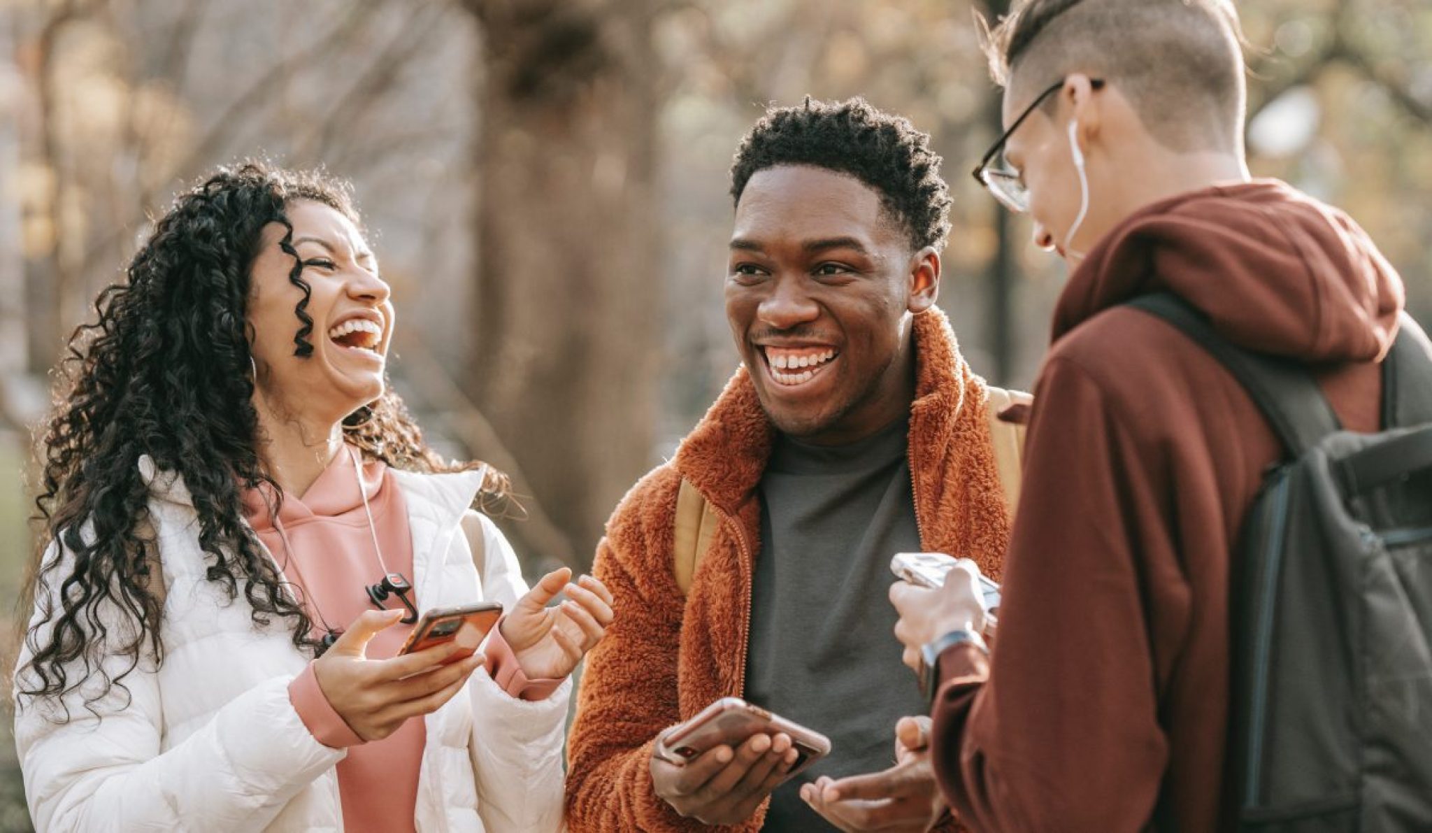 a group of people laughing and holding phones